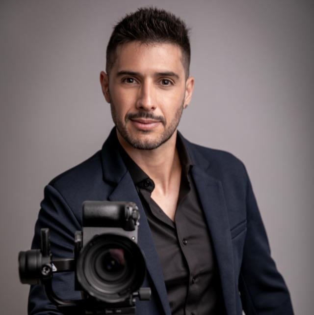 Rodrigo Salles de blazer escuro, com uma câmera à sua frente